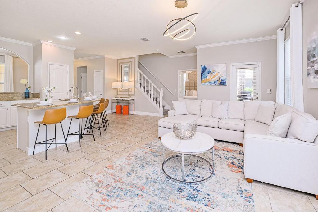 a living room with a white couch and a table at Solterra Resort Home - Waterslide and Lazy River in Davenport