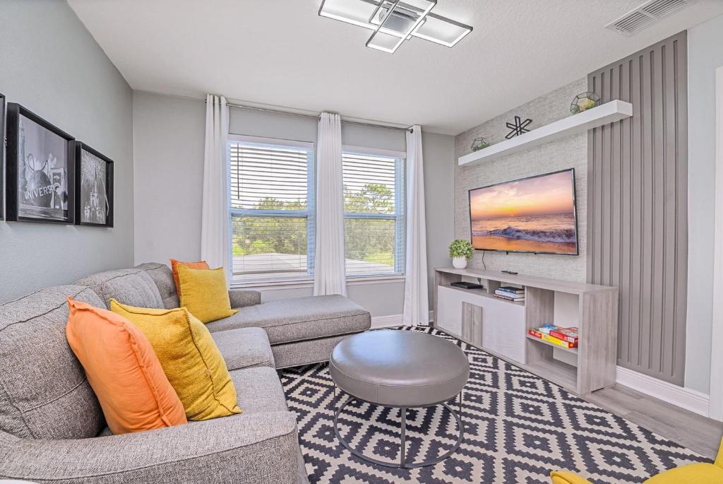 a living room with a couch and a tv at Solterra Resort Home - Waterslide and Lazy River in Davenport