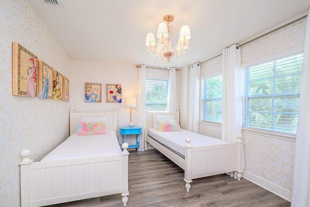 a bedroom with two beds and a chandelier at Solterra Resort Home - Waterslide and Lazy River in Davenport