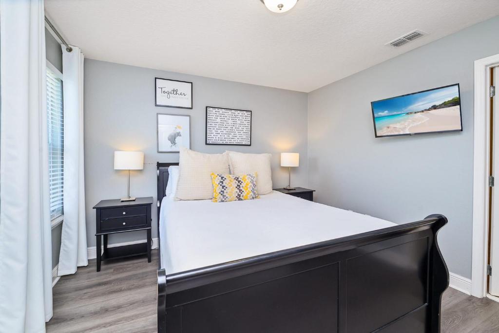 a bedroom with a large bed and two lamps at Solterra Resort Home - Waterslide and Lazy River in Davenport