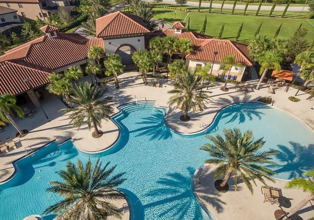 an aerial view of a resort swimming pool with palm trees at Solterra Resort Home - Waterslide and Lazy River in Davenport