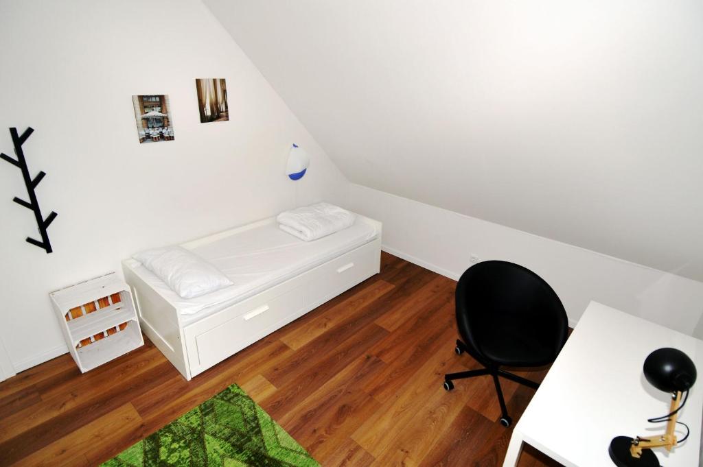 a bedroom with a bed and a desk and a chair at Kugelberg 13 in Heiligenhafen