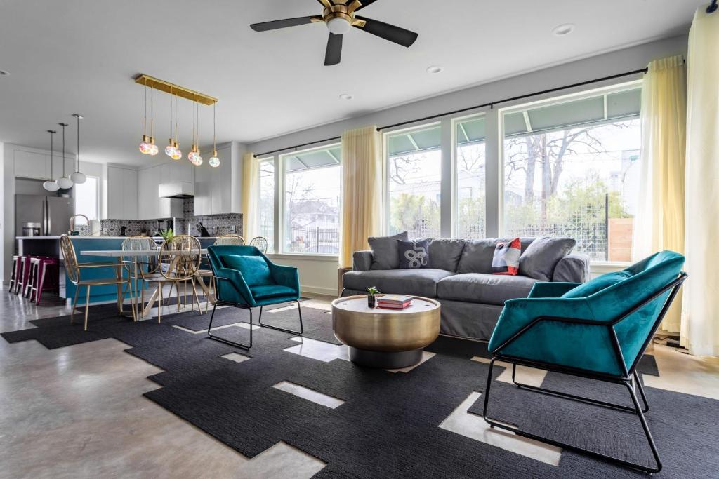 ein Wohnzimmer mit Sofa, Stühlen und einem Tisch in der Unterkunft Insa Worthy Two-Home Retreat - Fire Pit, Hot Tub in Austin