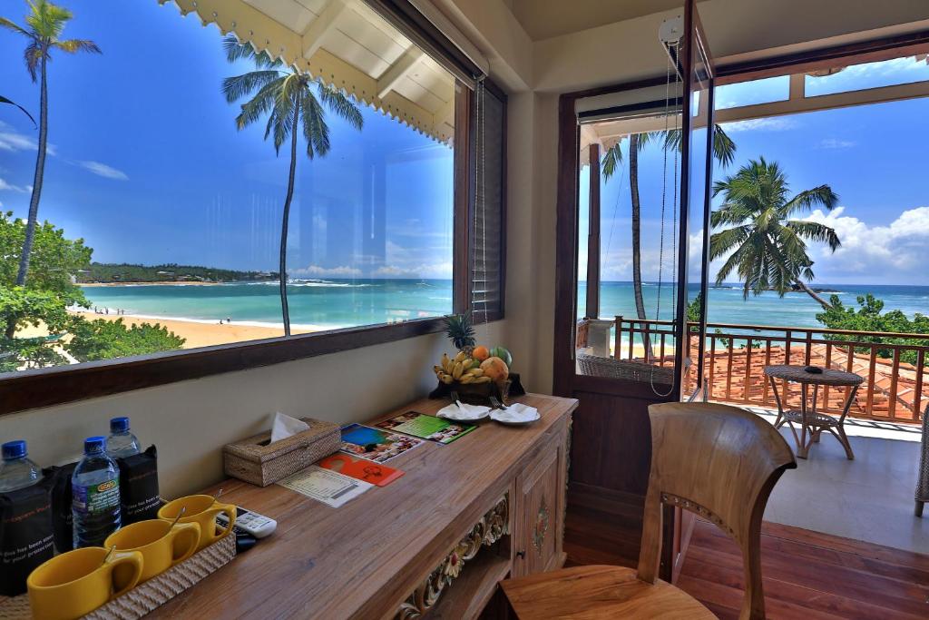 a kitchen with a table with a view of the beach at Thaproban Beach House in Unawatuna