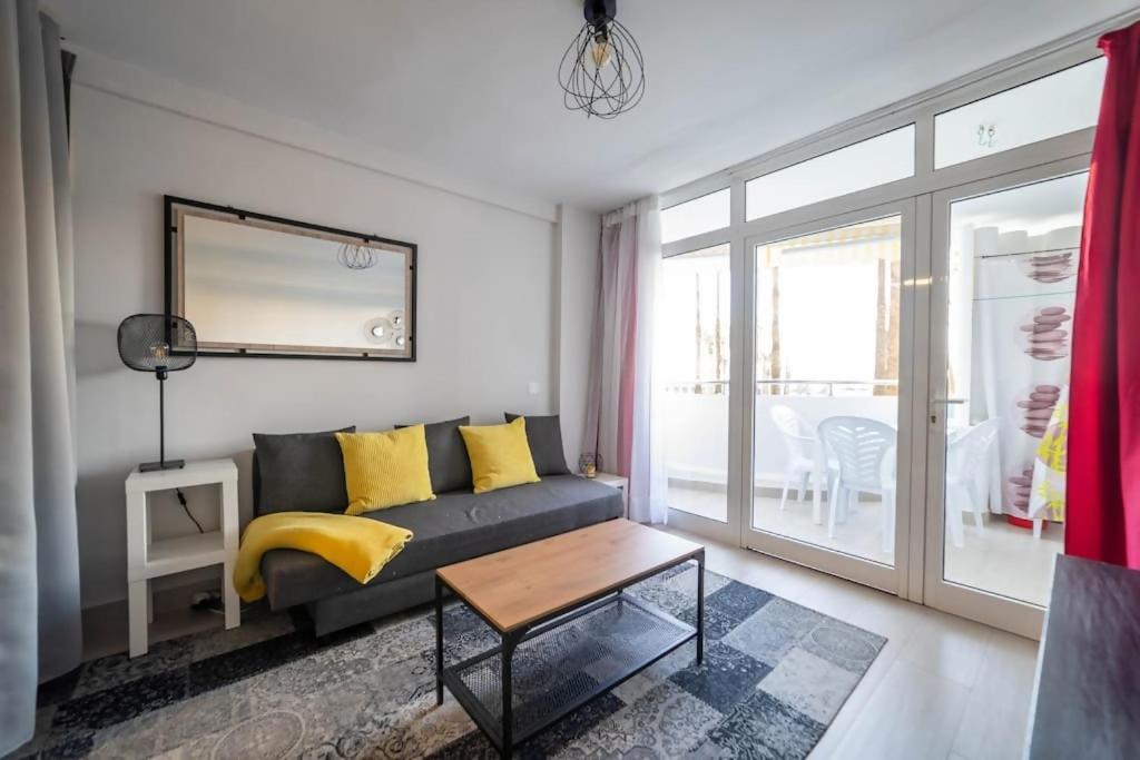 a living room with a couch and a table at Paraiso maspalomas sunset by CALIMA HOMES in San Bartolomé