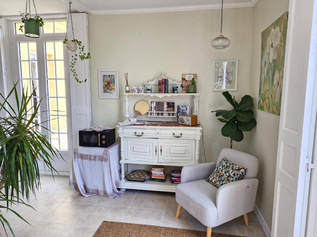 a living room with a chair and a dresser at Maison Coqueréaumont in Montagne
