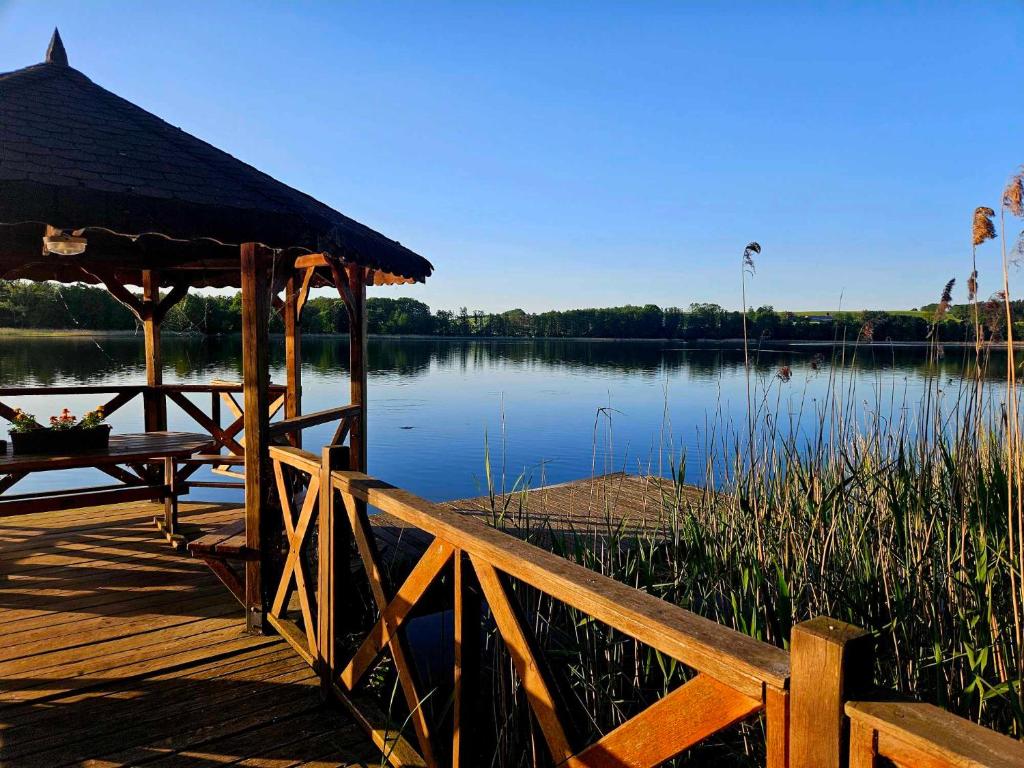 muelle de madera con cenador junto a un lago en Drzemalik wypoczywaj z KLASĄ, en Mikołajki Pomorskie