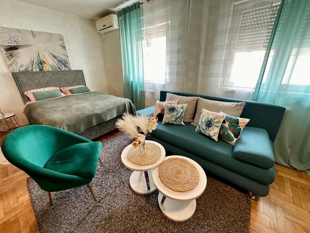 - un salon avec un canapé vert et 2 tables dans l'établissement Belgrade Apartment 1, à Zvezdara