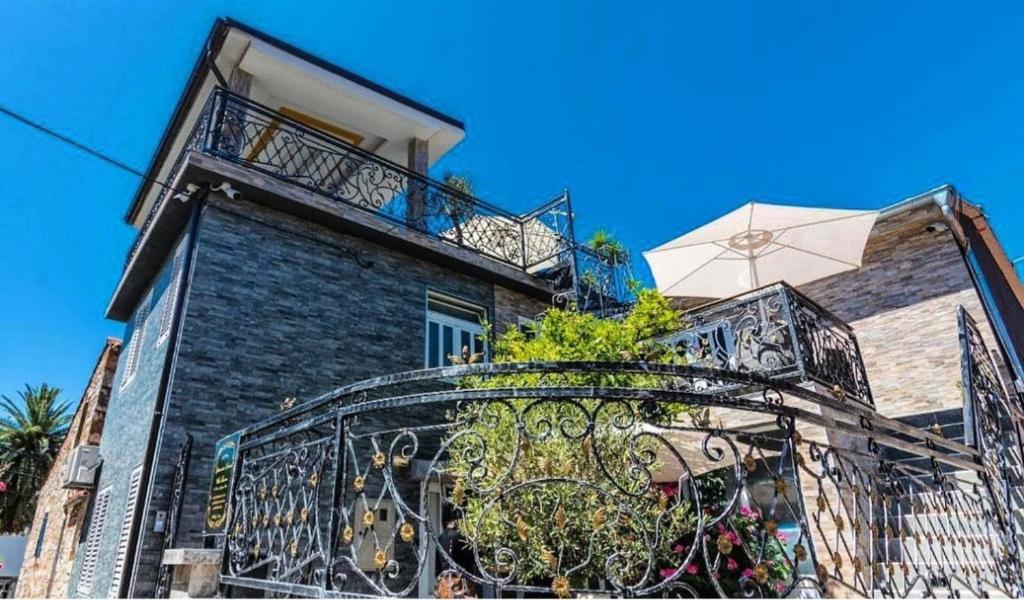 a building with a balcony with plants on it at Villa MAJESTIC in Mali Lošinj