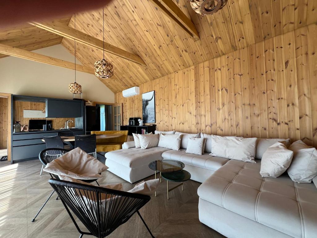 a living room with a white couch and wooden walls at Viesuli Village Villa in Saraiķi