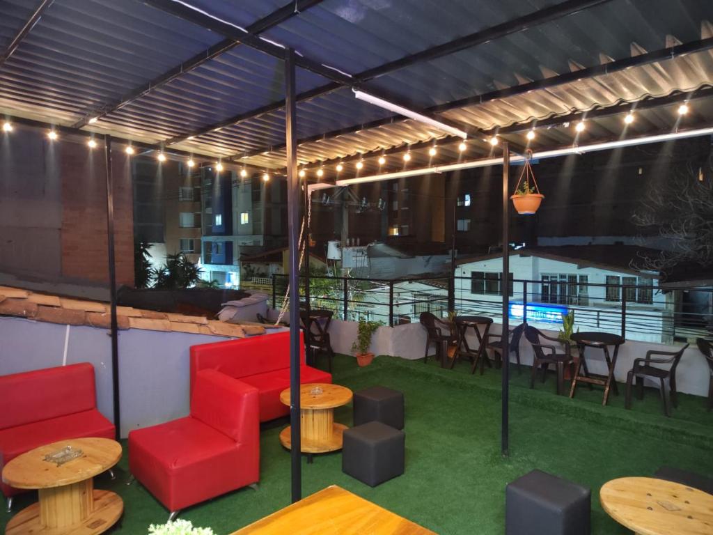 un patio con mobili rossi, tavoli e sedie di Absolute Hotel & Hostel Boutique a Medellín