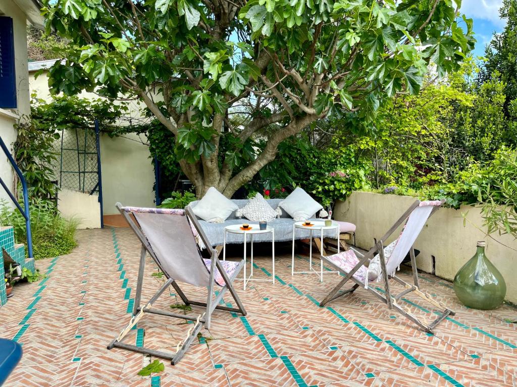 d'une terrasse avec une table, des chaises et un arbre. dans l'établissement House Garden Paris, à Saint-Maurice