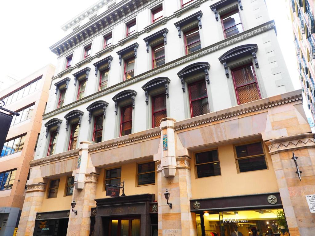 a large white building with a lot of windows at Flinders Lane Apartments in Melbourne