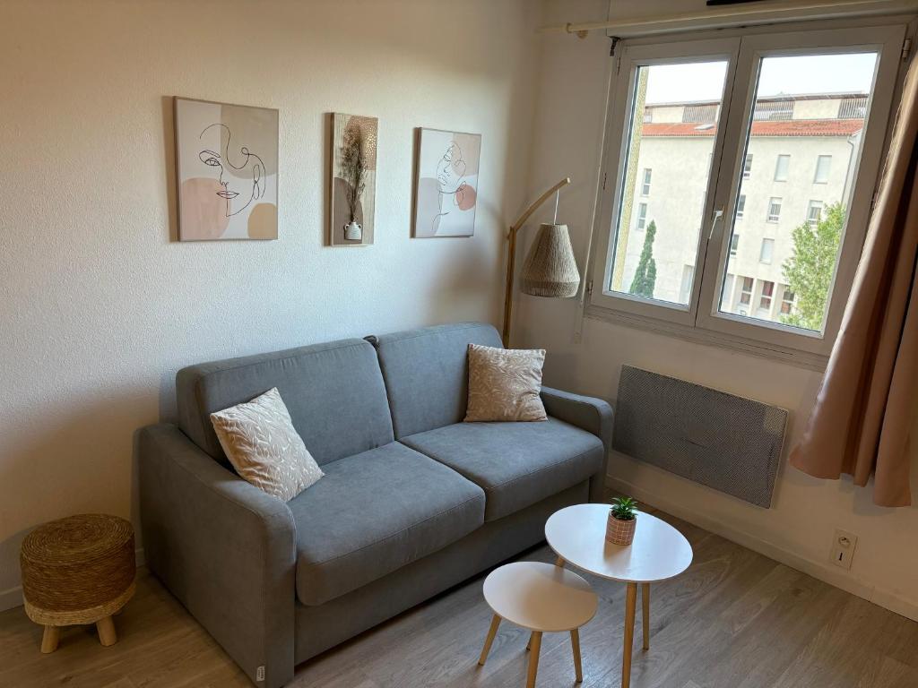 un salon avec un canapé bleu et une table dans l'établissement Au cocon du palais, à Avignon