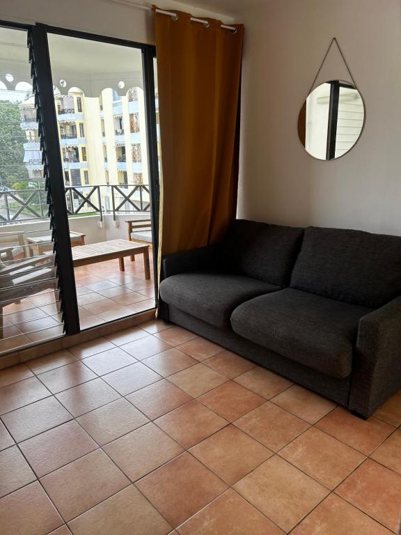 uma sala de estar com um sofá e uma varanda em Prestige em Fort-de-France