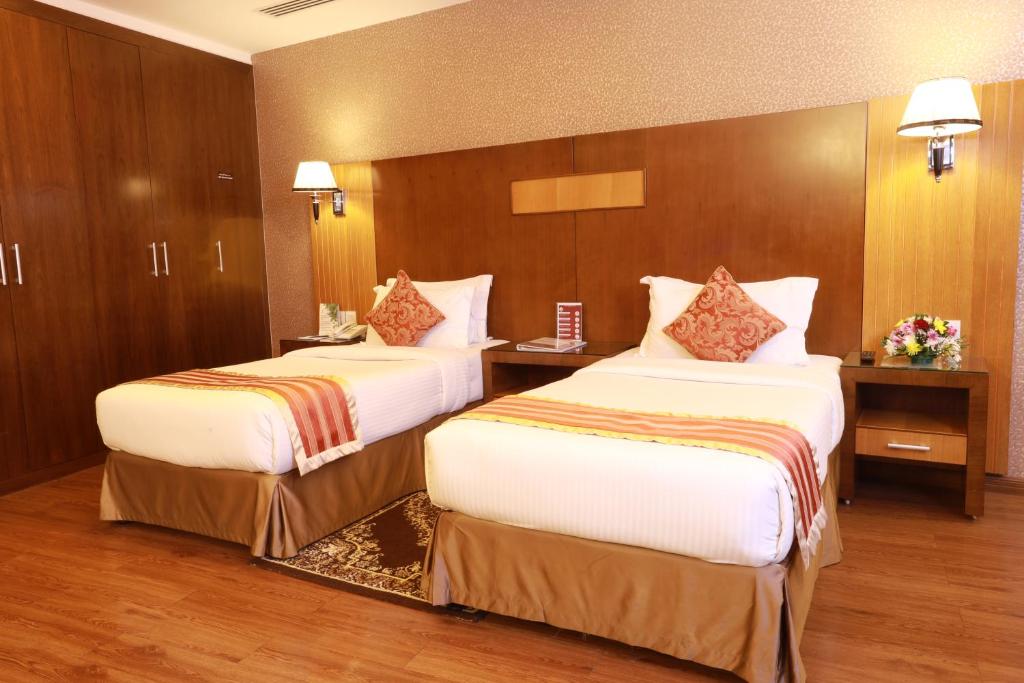 a hotel room with two beds in a room at Fortune Pearl Hotel in Dubai
