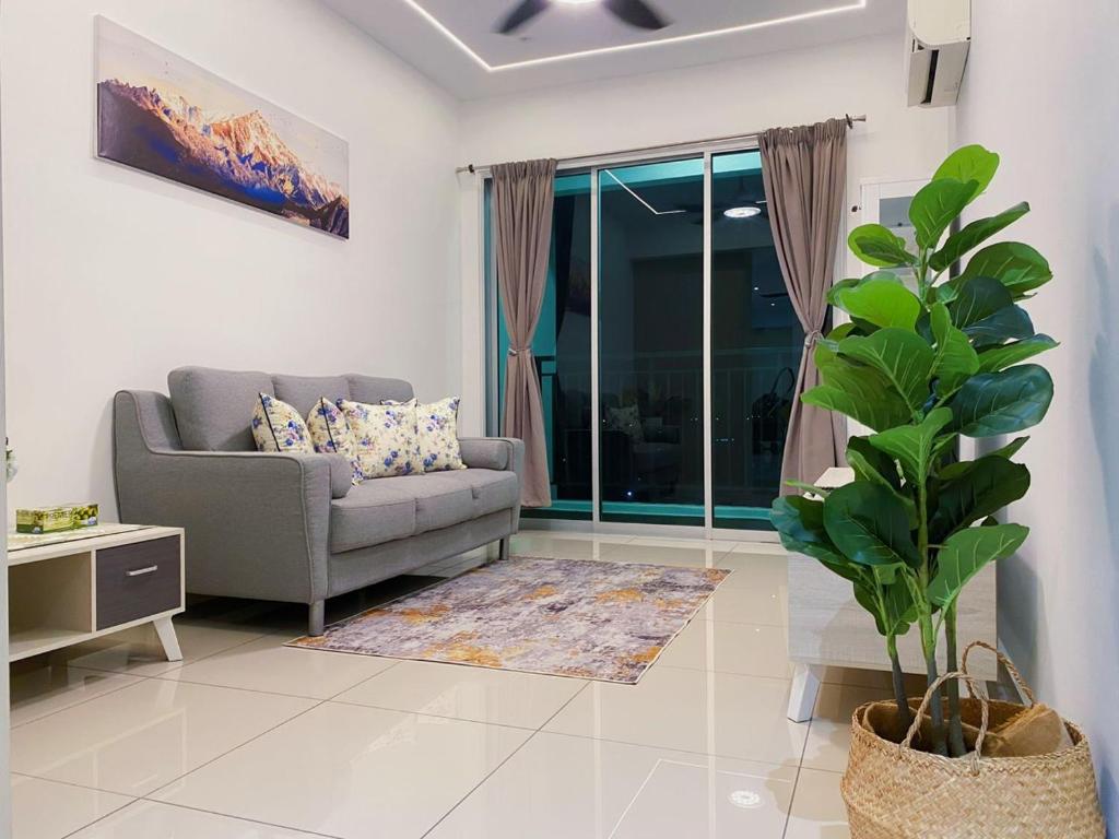 un salon avec un canapé et une plante dans l'établissement Newly Furnished Metropol Service Apartment with Attractive View, à Bukit Mertajam