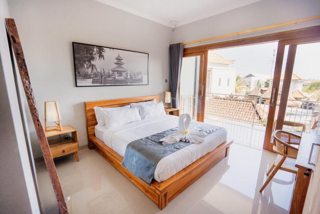 a bedroom with a bed and a large window at Kubu Gena Guesthouse Canggu in Canggu