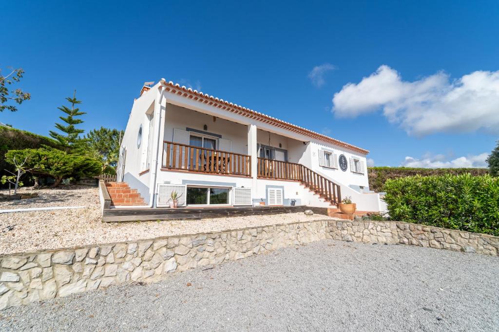 een groot wit huis met een stenen muur bij AnchorHouse Portugal in Aljezur