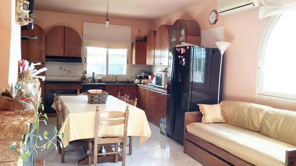 uma cozinha com uma mesa e um frigorífico preto em One bedroom villa with shared pool and enclosed garden at Augusta 8 km away from the beach em Augusta