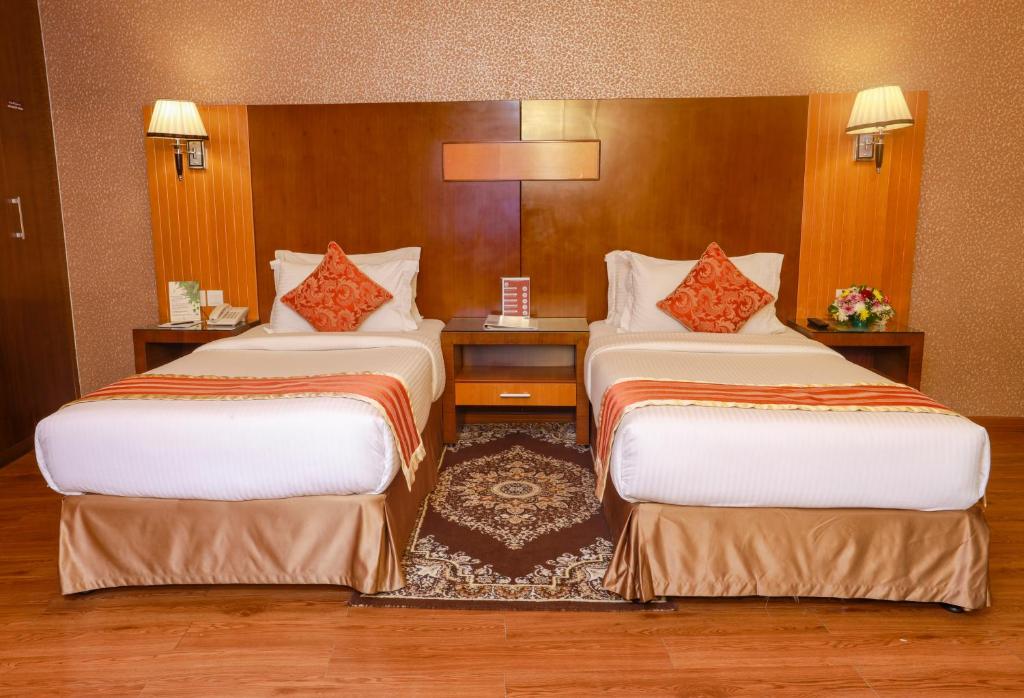a hotel room with two beds in a room at Fortune Pearl Hotel in Dubai