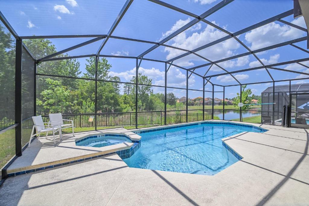 a swimming pool in a glass house at Stunning 9BR Home - Family Resort with Private Pool, Hot Tub, Games room and BBQ! in Kissimmee