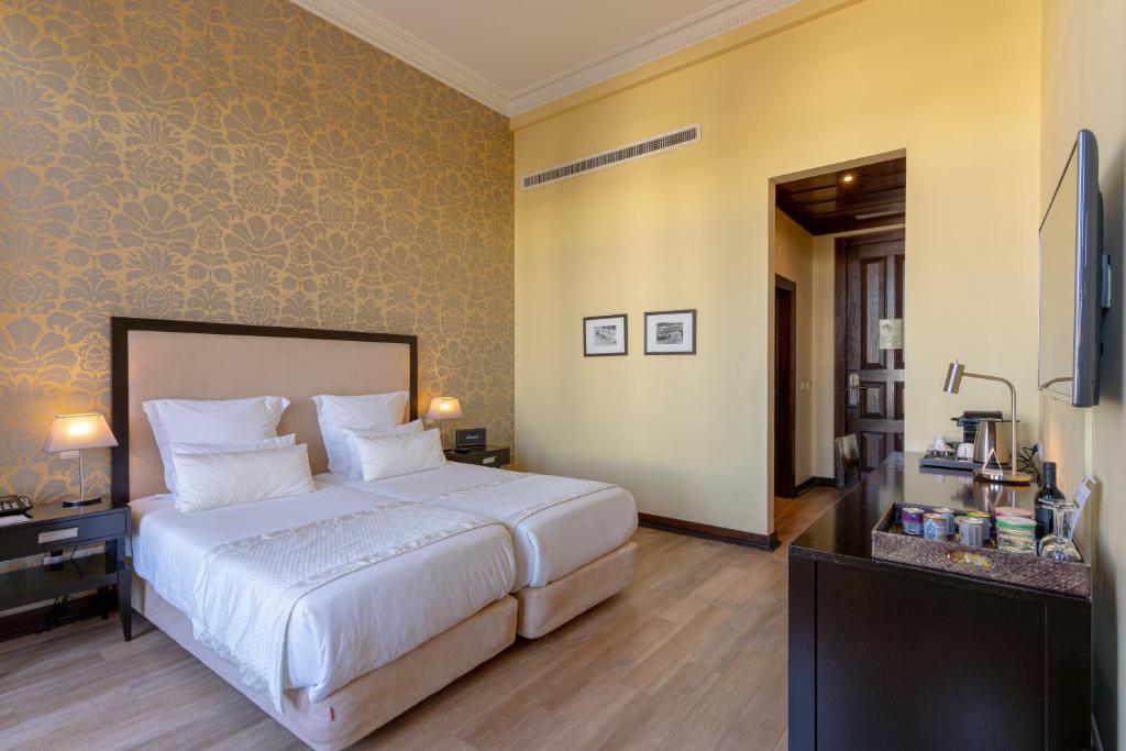 a bedroom with a large white bed in a room at Hotel Inglaterra - Charme & Boutique in Estoril