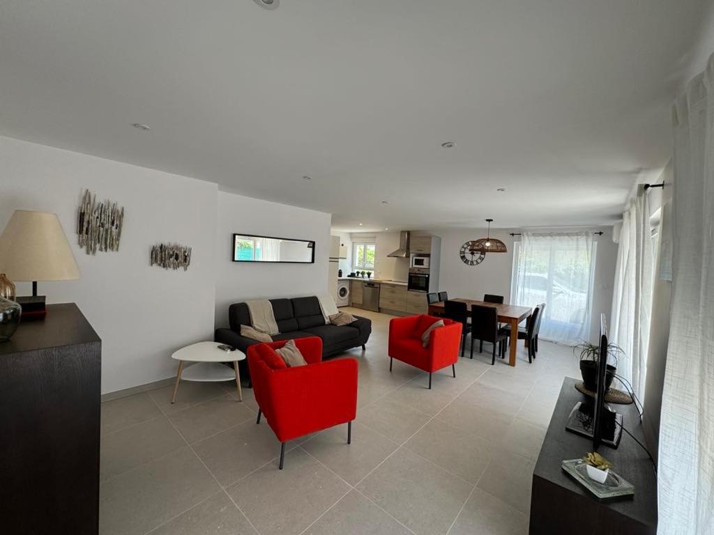 ein Wohnzimmer mit roten Stühlen und einem Sofa in der Unterkunft Chez Camille appartement spacieux 75m2 climatisation wifi parking terrasse et cour privative a 50 m de la plage in Le Grau-du-Roi