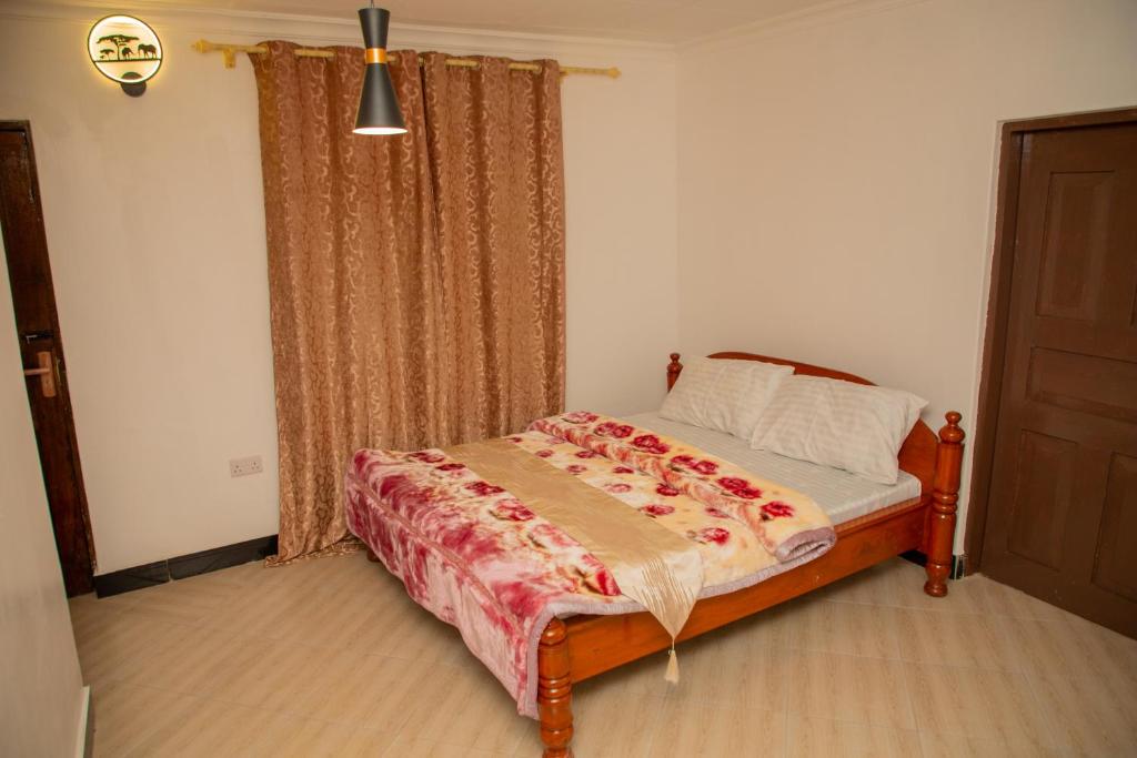 a bedroom with a bed and a window at Gangilonga Home's in Iringa