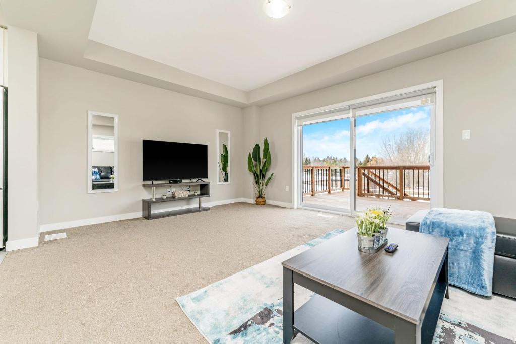 a living room with a tv and a couch at Serene 3BR Home - Sun Deck - Near Victoria Park in Kitchener