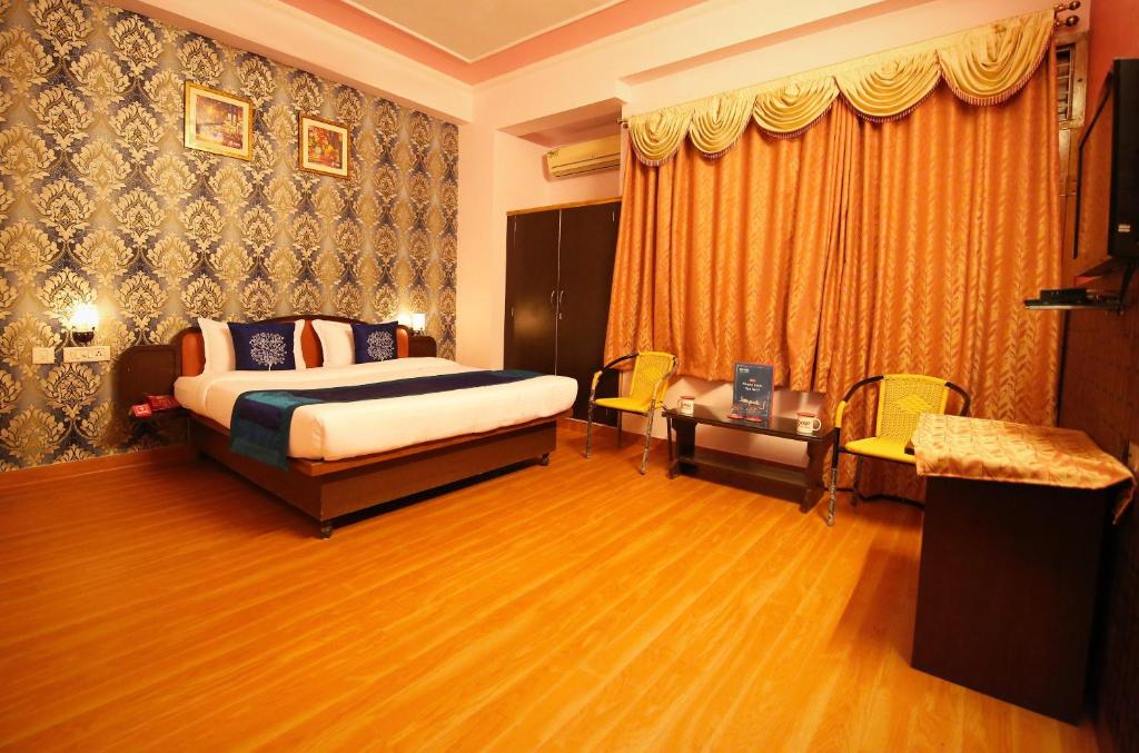 a hotel room with a bed and a table at Hotel Manohar Palace in Jaipur