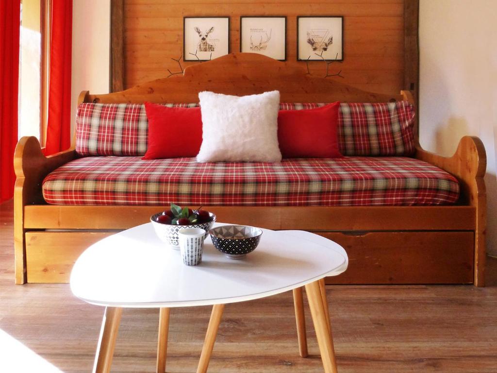 kanapę z czerwonymi poduszkami i białym stołem w obiekcie Appartement Valloire, 4 pièces, 8 personnes - FR-1-263-155 w mieście Valloire