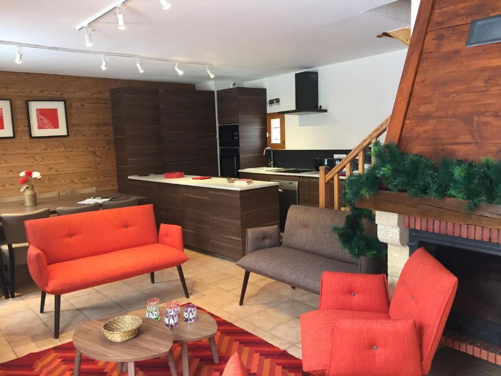 a living room with red chairs and a kitchen at Chalet Valloire, 6 pièces, 12 personnes - FR-1-263-360 in Valloire