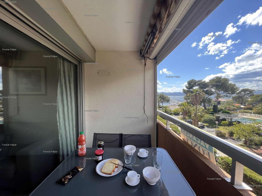 une table avec une assiette de nourriture sur un balcon dans l'établissement Studio cabine à St-Raphaël avec terrasse et parking, à 100m de la plage - FR-1-226A-23, à Saint-Raphaël