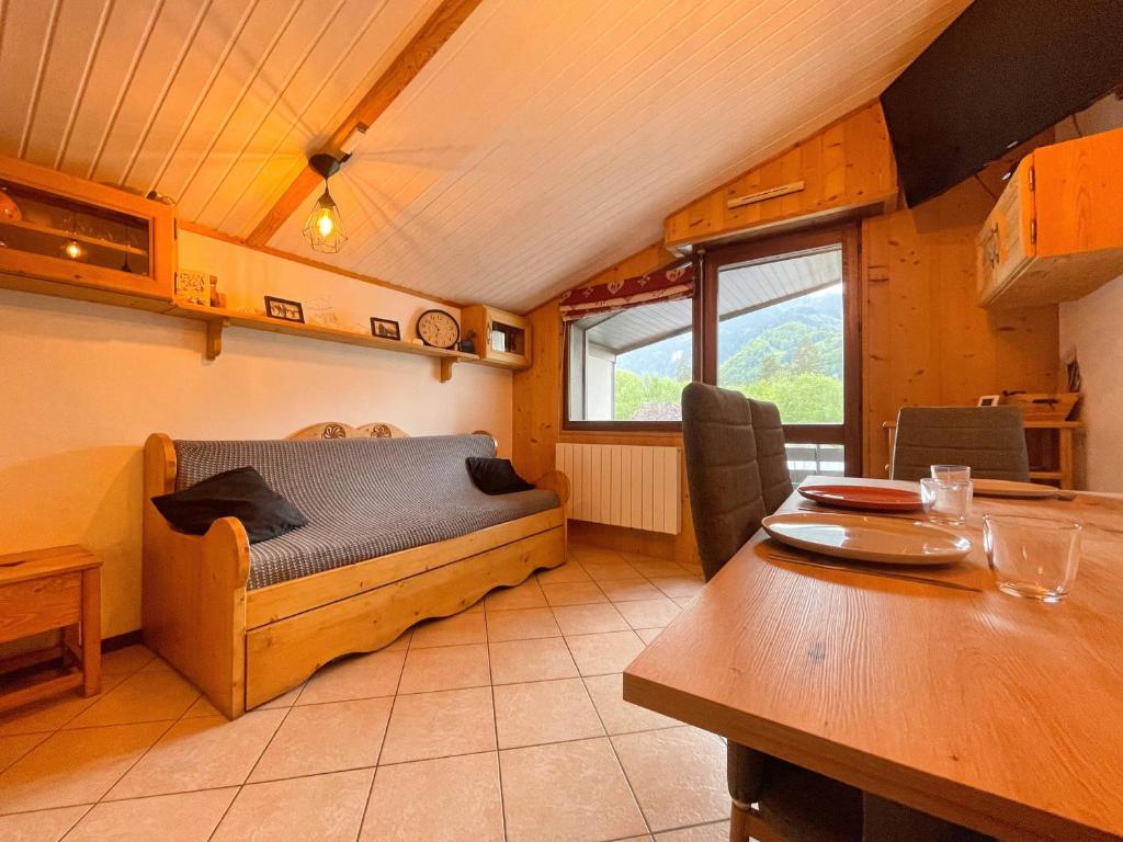 une chambre avec un lit et une table dans une pièce dans l'établissement Appartement Chaleureux avec Balcons au Coeur de Samoëns, Proche Ski-Bus - FR-1-624-147, à Samoëns