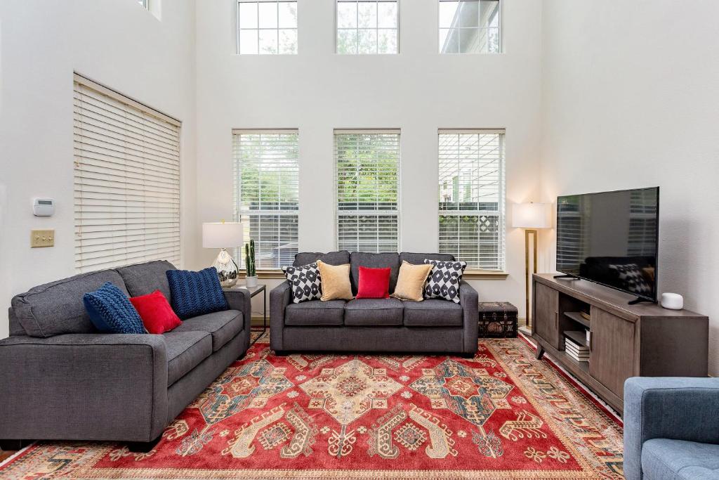 ein Wohnzimmer mit 2 Sofas und einem Flachbild-TV in der Unterkunft East Austin Family Home - 5 mins from downtown in Austin