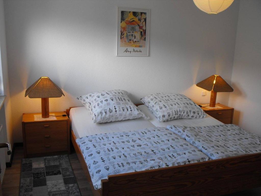 - une chambre avec un lit et 2 lampes sur les tables de chevet dans l'établissement Ferienwohnung Familie Kunz 34385 Bad Karlshafen, à Bad Karlshafen