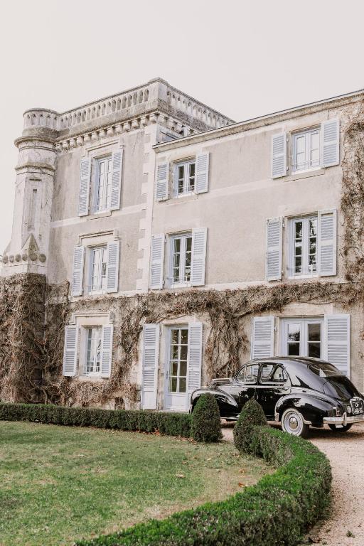 une voiture noire garée devant un bâtiment dans l'établissement Château du Serpolet, à Pont-du-Château