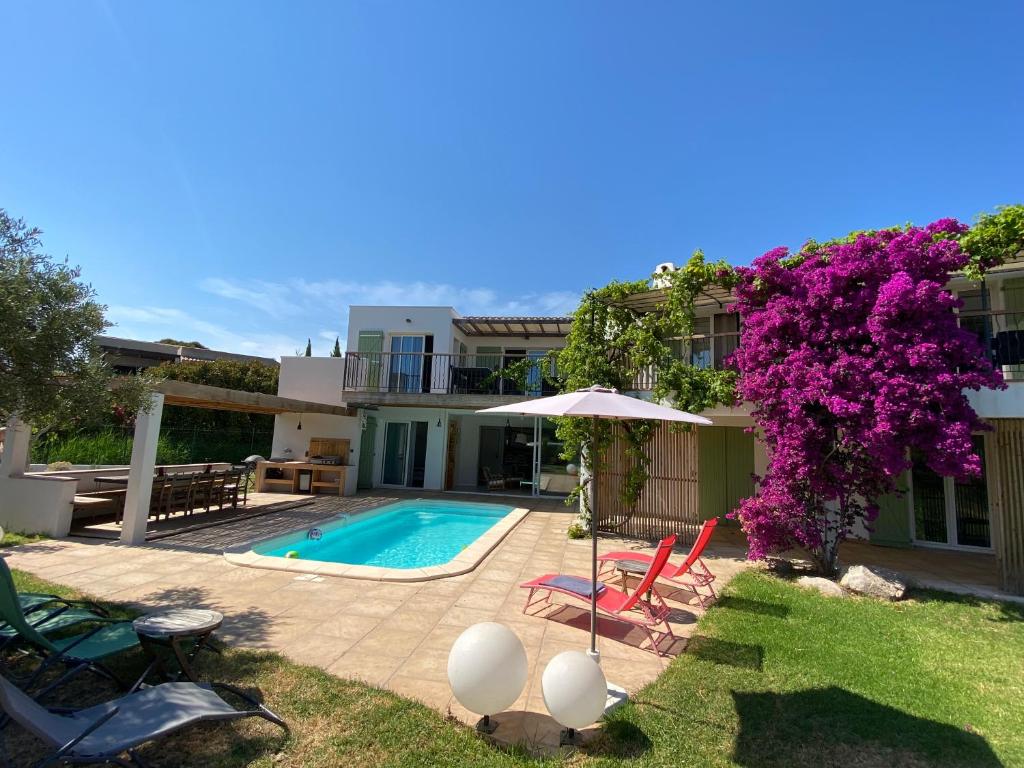 une cour arrière avec une piscine et une maison dans l'établissement Villa bord de mer avec piscine 200 métres plage, à Zonza