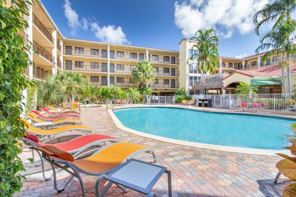 ボカラトンにあるHoliday Inn & Suites Boca Raton - Northのホテルのスイミングプールのそばのラウンジチェアの列