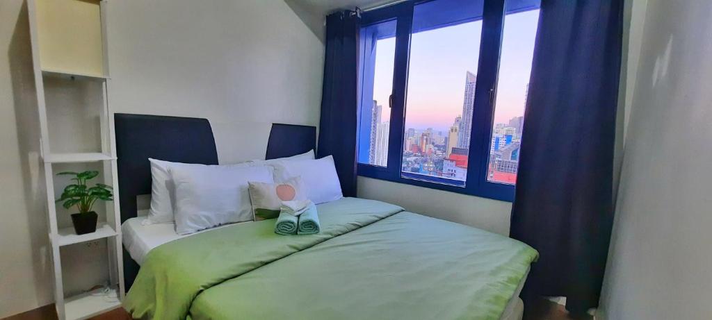 a small bedroom with a bed with a window at Air Residences great location in Makati CBD in Manila