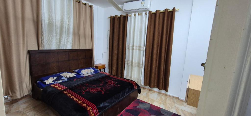 a bedroom with a bed in a room with curtains at Abo Amer Apartments in Aqaba