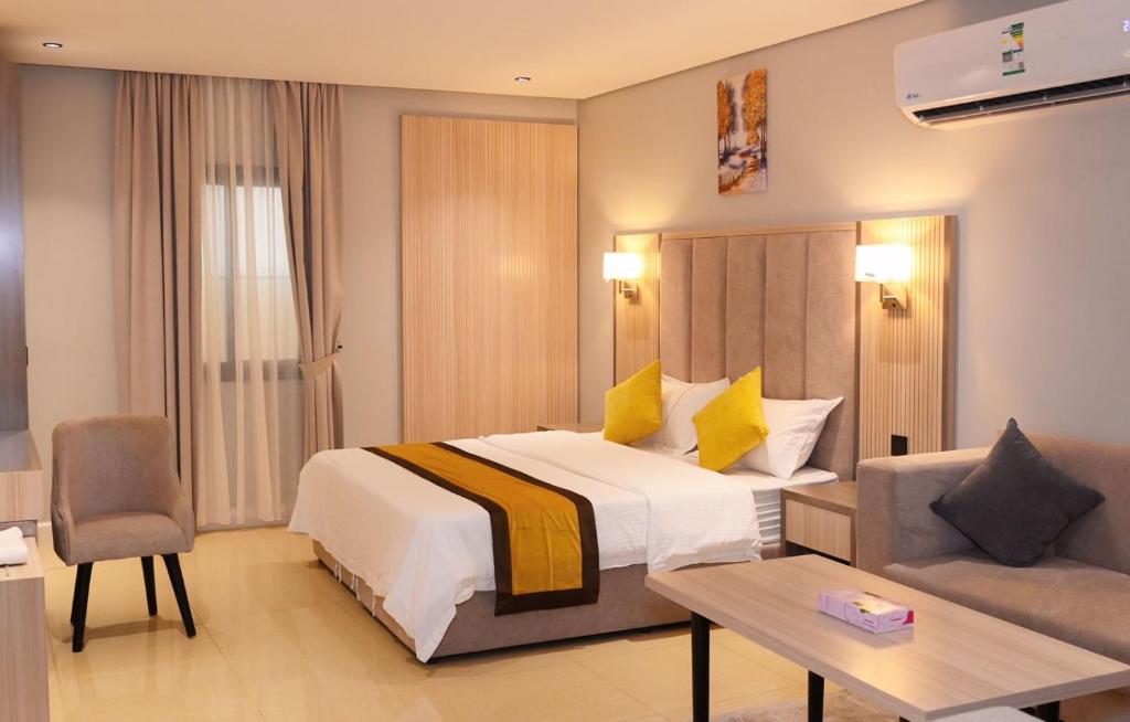 a hotel room with a bed and a couch at بلند للشقق المخدومة اقتصادي in Dammam