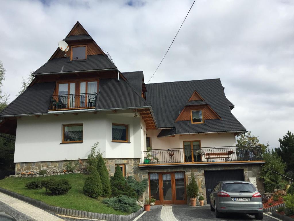 une grande maison avec un toit noir dans l'établissement U Dudy, à Kościelisko