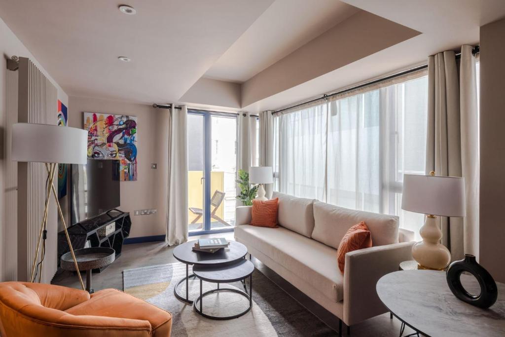 uma sala de estar com um sofá e uma grande janela em Urban Joy - Holborn By Frankie Says em Londres