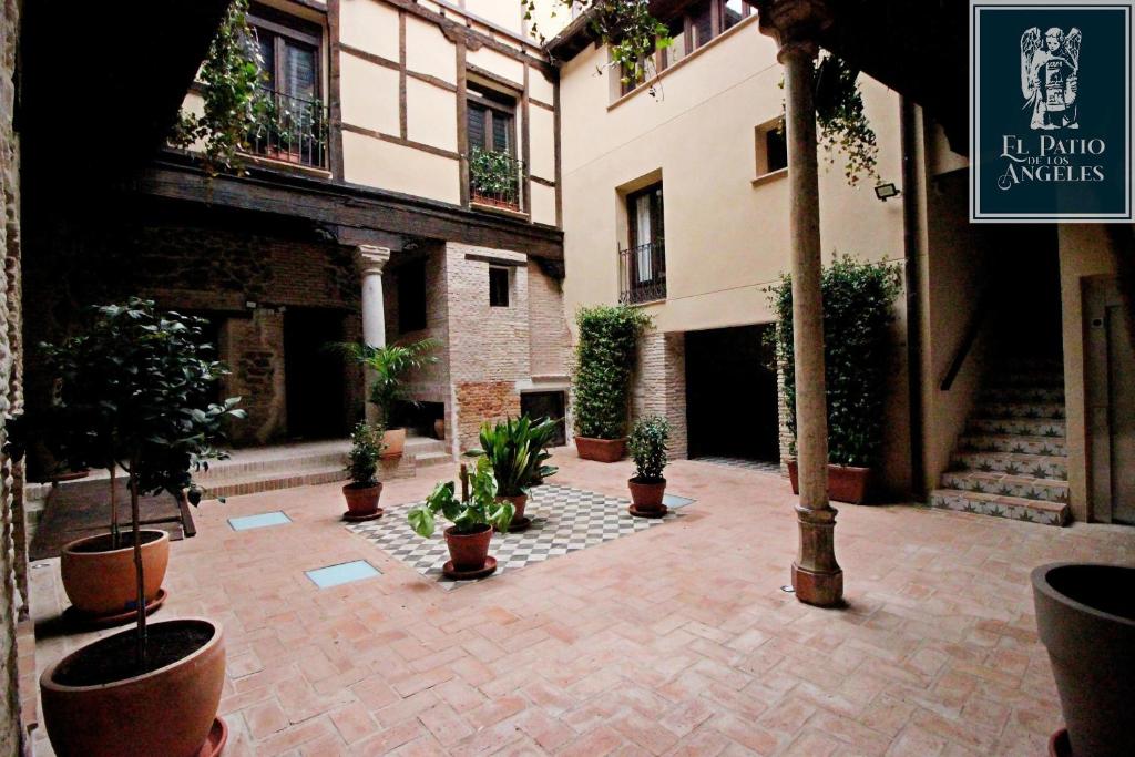 an empty courtyard with potted plants in a building at Patio de los Ángeles in Toledo