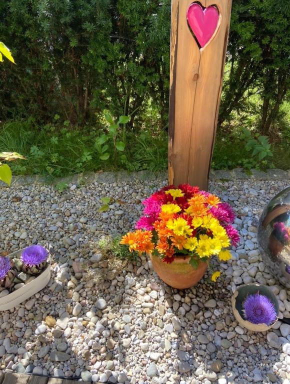 a garden with flowers and a heart on a post at Ferienwohnung Alpenruhe in Schönau am Königssee