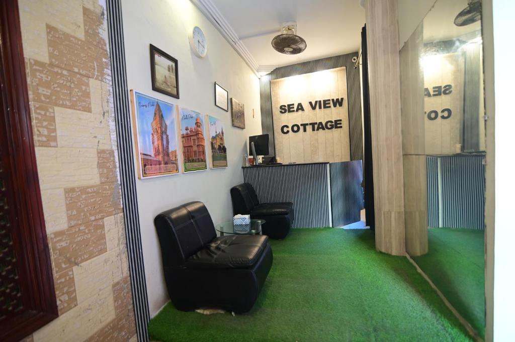 una sala de espera con silla de cuero y alfombra verde en SEAVIEW COTTAGE, en Karachi