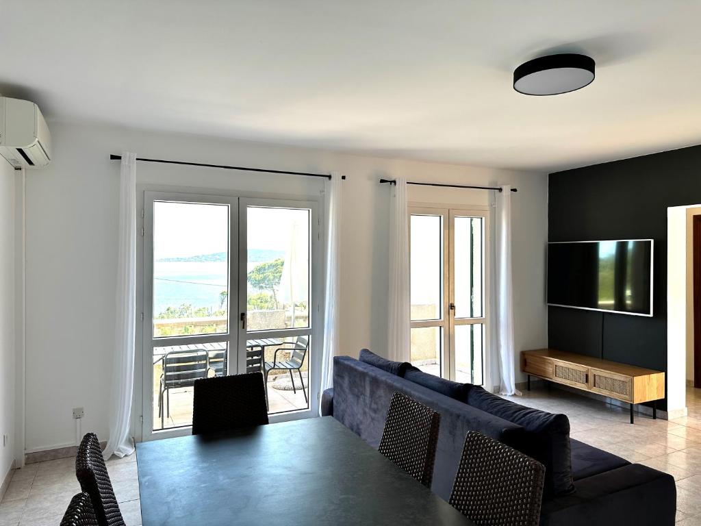 a living room with a couch and a table with a television at Résidence Aigue Marine in Coti-Chiavari