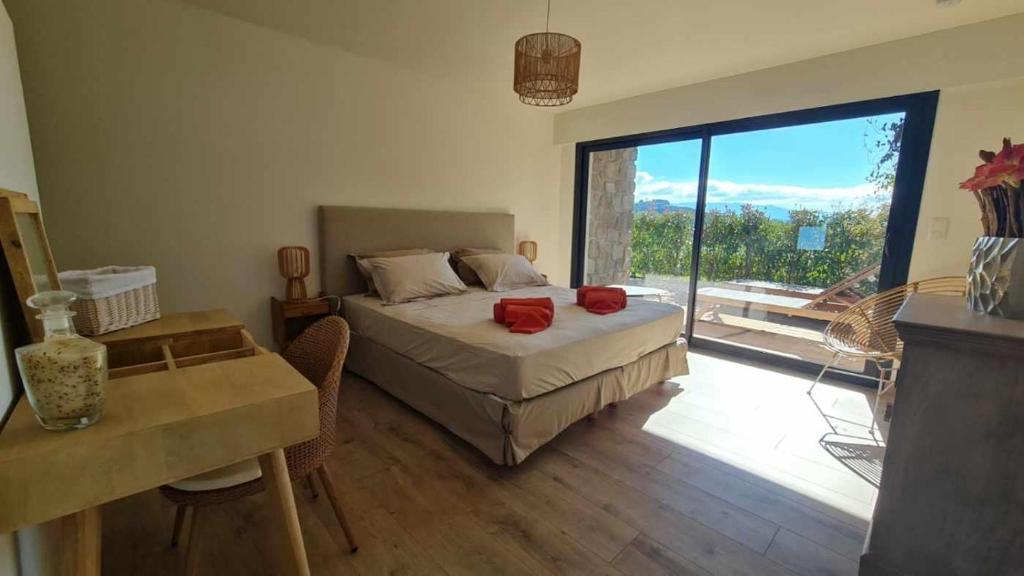 une chambre avec un lit et une grande fenêtre dans l'établissement Proche porticcio, Coup de cœur asuré,Appartement de standing, rez de villa 6 couchages, climatisé à 150m de la plage, terrains de tennis, à Grosseto-Prugna